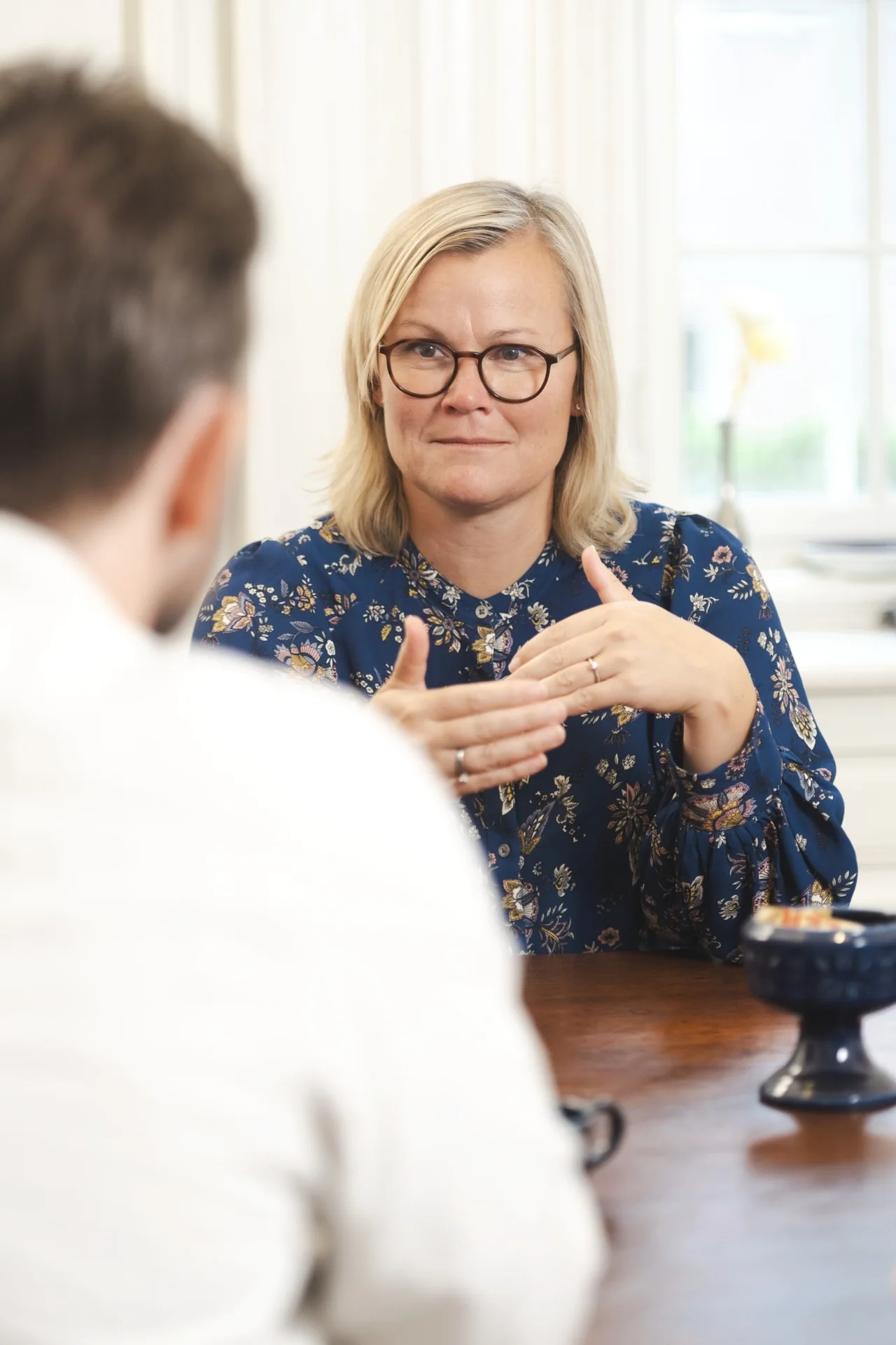 Maria rådgiver en boligkøber ved bordet