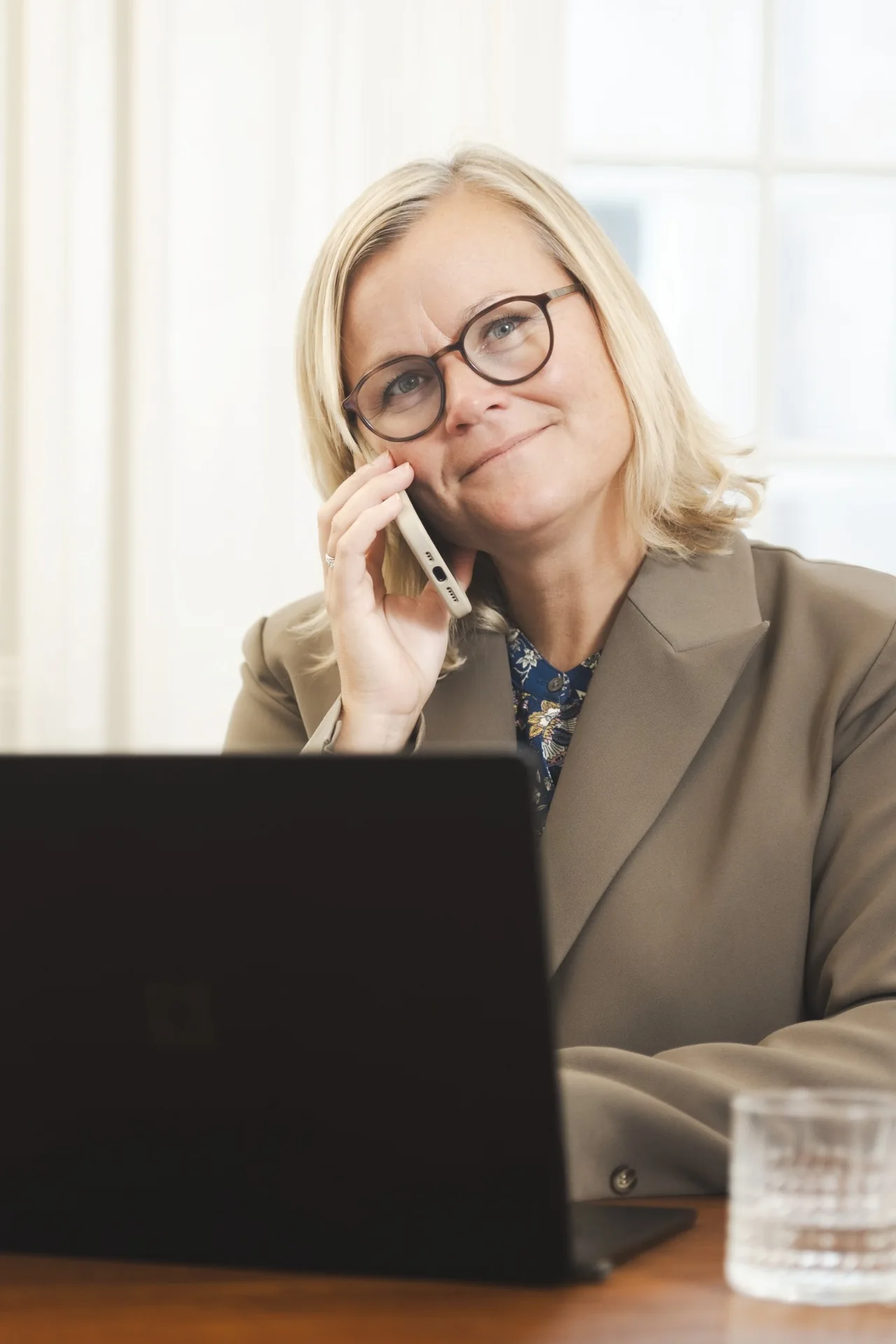 Maria Lindholm på telefon ved sin computer